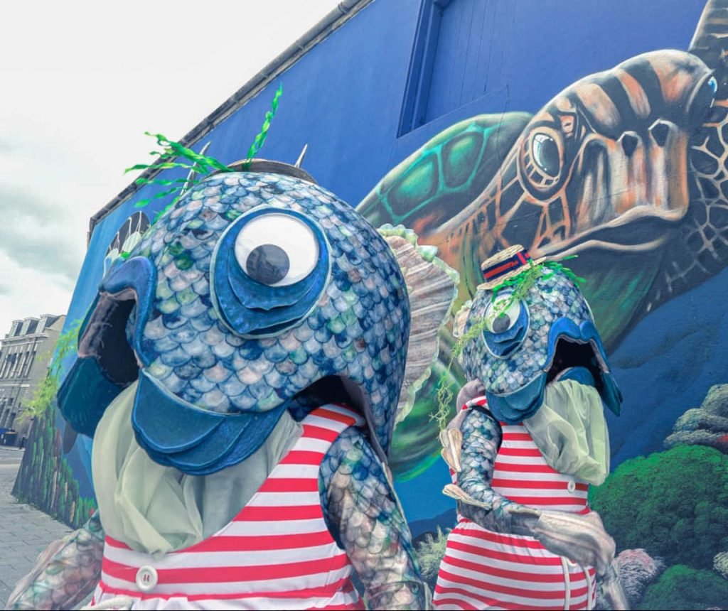 Two performers dressed as reverse mermaids with the fish half on top