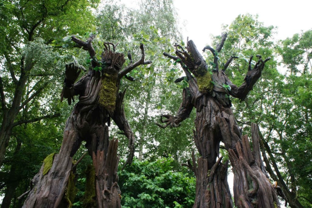 a pair of stilt walkers dressed as tree in an enchanted forest