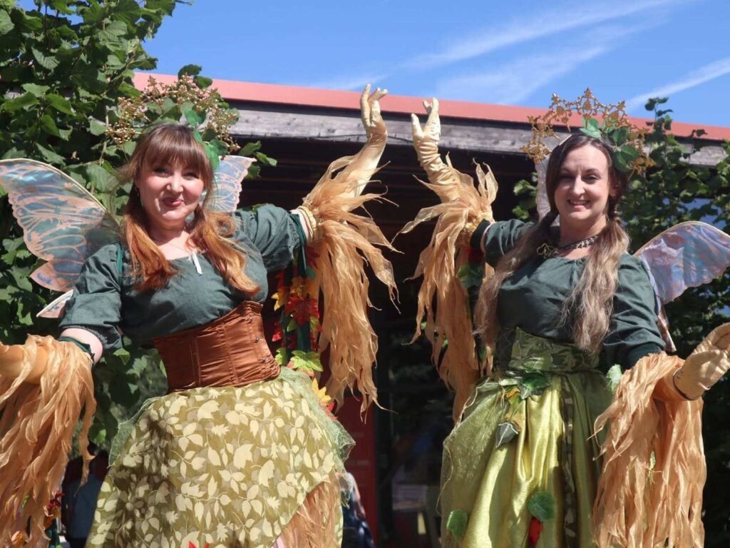 Two performers from Helter Skelter Arts in woodland themed costumes