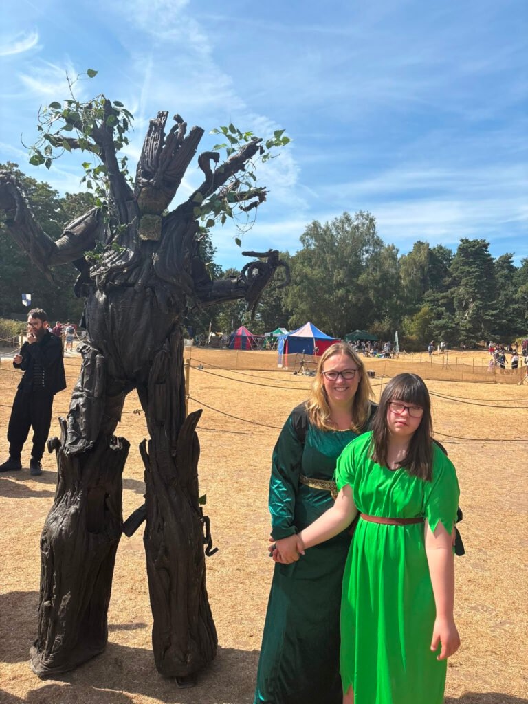 NWCSG pictured in period dresses with a tree walkabout performer