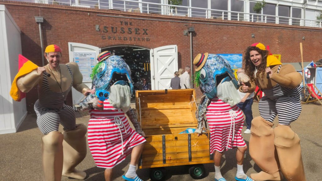 Four performers stood around a treasure chest on wheels, each wearing seaside themed outfits